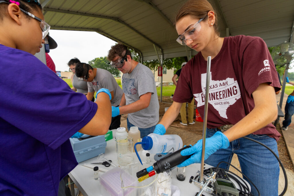 Student wearing safety glasses anf conducting an experiment.